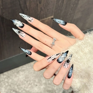 Dark blue stiletto press-on nails with butterfly designs and 3D pearls on hand