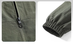 Detail of army green outdoor jacket featuring black zipper puller and elastic cuffs