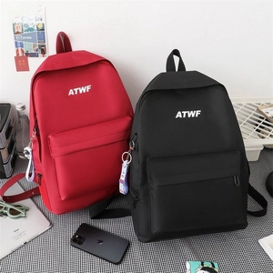 Detail view of red and black ATWF backpacks with laptop and tech gadgets on a desk