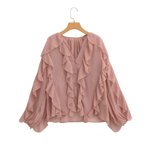 Detail of pink chiffon blouse featuring elegant layered ruffles and classic V-neckline