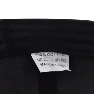 Close-up of the internal 100% cotton wash label and stitching on a black baseball cap