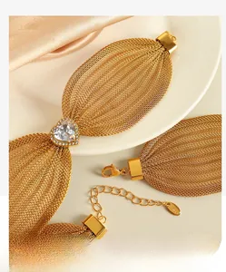 Detail of gold multi-layer mesh bracelet with heart-shaped zircon and S.Steel tag
