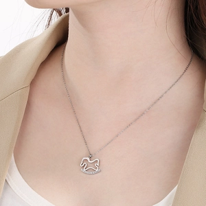 Close-up of a silver rocking horse pendant with rhinestones on a delicate chain