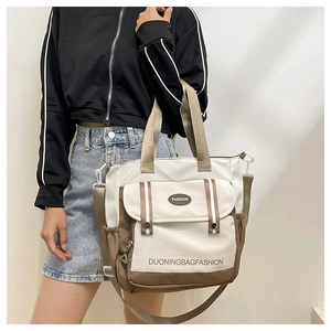 Detail of canvas bucket bag with fashion lettering and multi-pocket design on the front