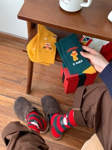 Cozy Christmas cotton socks with gingerbread and Santa patterns on a wooden floor