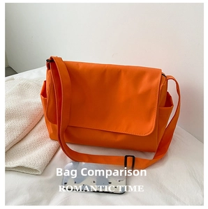 Detailed view of orange messenger bag showing side pockets and large flap closure