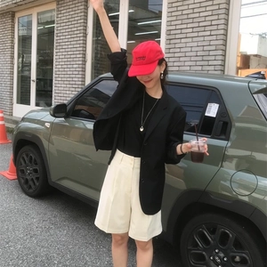 Minimalist saddle bag pendant necklace paired with black blazer and red baseball cap