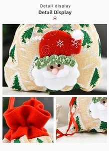 Detail view of burlap Christmas drawstring gift bag with Santa Claus 3D applique