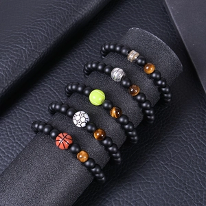 Detail of 5 sports bracelets with matte onyx beads, tiger eye stone and various ball charms