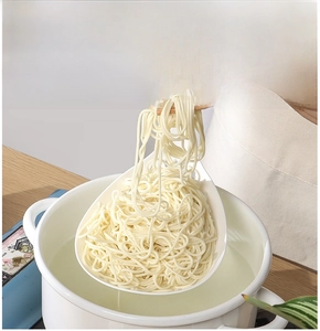 Macro view of wide heat-resistant strainer scooping noodles in deep kitchen ladle