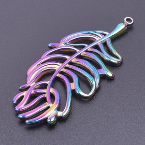 Macro shot of rainbow stainless steel leaf pendant with delicate hollow-out details