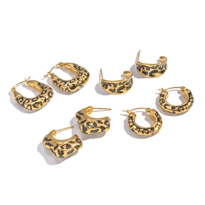 Golden hoop earrings set with leopard print enamel patterns on white background