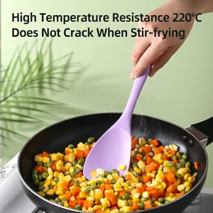 Purple heat-resistant silicone spatula stirring mixed vegetables in a non-stick pan