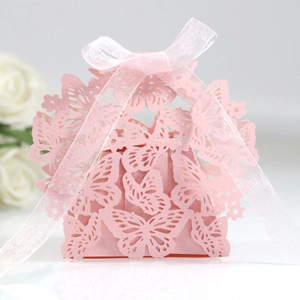 Pink laser-cut butterfly wedding favor box with a white ribbon and delicate pearl finish