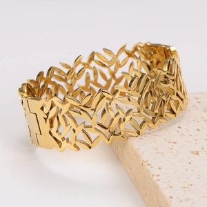 Polished gold cutout leaf texture stainless steel cuff bracelet on stone base