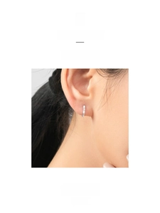 Close-up of minimalist S925 sterling silver huggie earrings with sparkling cubic zirconia