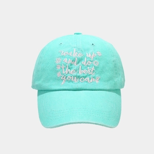 Detail of mint green washed cotton baseball cap with white cursive motivational embroidery