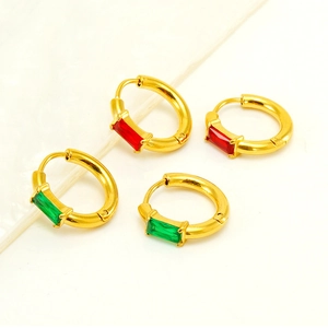 Detail of gold square earrings with baguette-cut red and green zircon stones