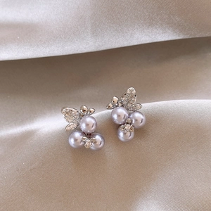 Elegant silver earrings with purple pearls and rhinestone leaf cluster on silk fabric
