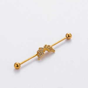 Golden industrial barbell earring with crystal-encrusted wings on polished stainless steel