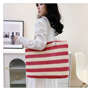 Detail showing the large striped woven shoulder bag with stylish knotted strap detail
