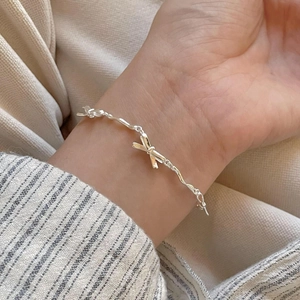 Elegant S925 sterling silver bow bracelet on model wrist with minimalist link chain