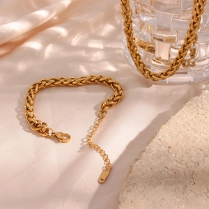 Detail of a 6mm gold wheat chain bracelet with adjustable lobster clasp on silk
