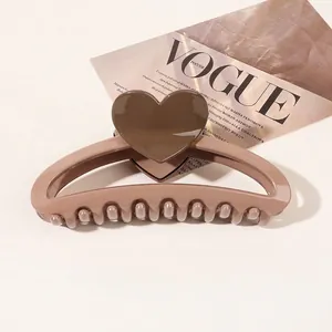 Detailed view of a coffee brown heart claw clip made of resin on a fashion magazine