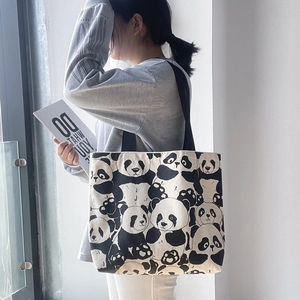 Detail of cute panda print canvas tote bag with black strap and large capacity