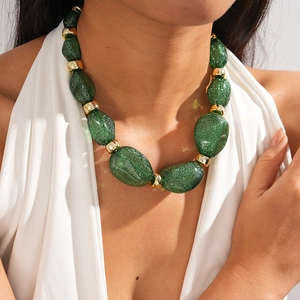Detail of chunky green resin beads and gold metal spacers on a vintage statement necklace