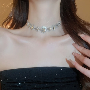 Close-up of elegant silver oval rhinestone choker necklace set worn by a model