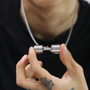 Detailed view of silver stainless steel dumbbell pendant necklace worn by a male model