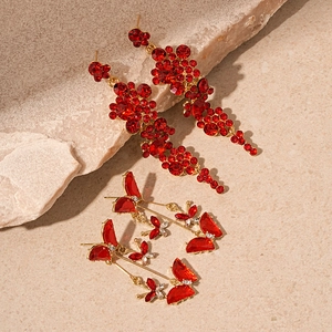 Vintage red rhinestone butterfly flower tassel earrings on a natural stone background