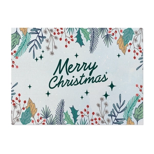 Detail of Christmas cotton linen placemat with green plant prints and Merry Christmas text