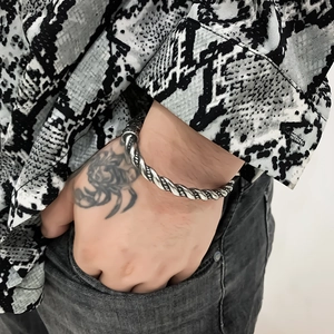 Close-up of men's Viking dragon silver twisted rope bracelet worn on wrist