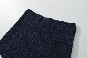 Dettaglio del tessuto bouclé blu navy che mostra la texture e i dettagli delle fibre