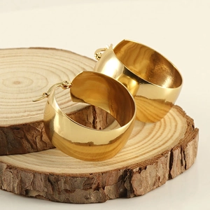 Pendientes de aro minimalistas en acero inoxidable dorado sobre base de madera