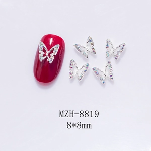 Macro detail of 8x8mm silver hollow butterfly nail charms with iridescent AB rhinestones