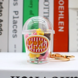 Detailed close-up of a mini 3D popcorn cup keychain with gold chain and colorful star beads