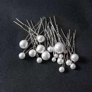 Macro detail of pearl U-shaped hair pins set for bridal wedding hairstyling accessories