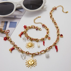 Détail de la chaîne en acier doré 18K avec pendentifs piment, cœur et fleurs