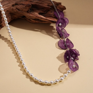 Detail of beaded necklace with white faux pearls and delicate purple chiffon flower petals