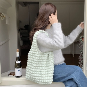 Close-up of light green cloud bubble tote bag with pleated texture on female model