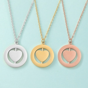 Close-up of rotating heart pendant necklaces in silver, gold, and rose gold finishes
