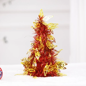 Detail of red foil tabletop tree with gold bow ornaments for holiday decoration