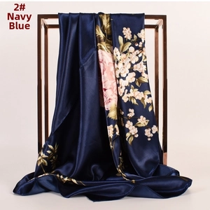 Dettaglio di sciarpa quadrata in raso blu navy con motivi floreali di peonie rosa su rack