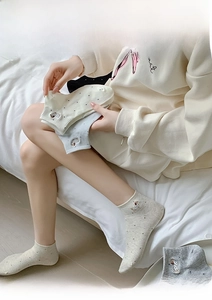 Close-up of cute cartoon dog embroidery and polka dot patterns on soft cotton socks