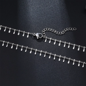 Detailed view of silver stainless steel necklace with small pendants and lobster clasp