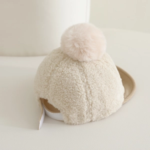 Détail de la casquette hiver pour bébé en polaire sherpa avec pompon doux