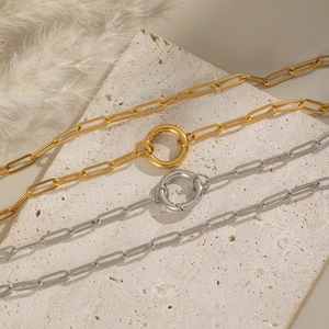 Detail of paperclip chain in gold and silver finish with round spring clasps on stone